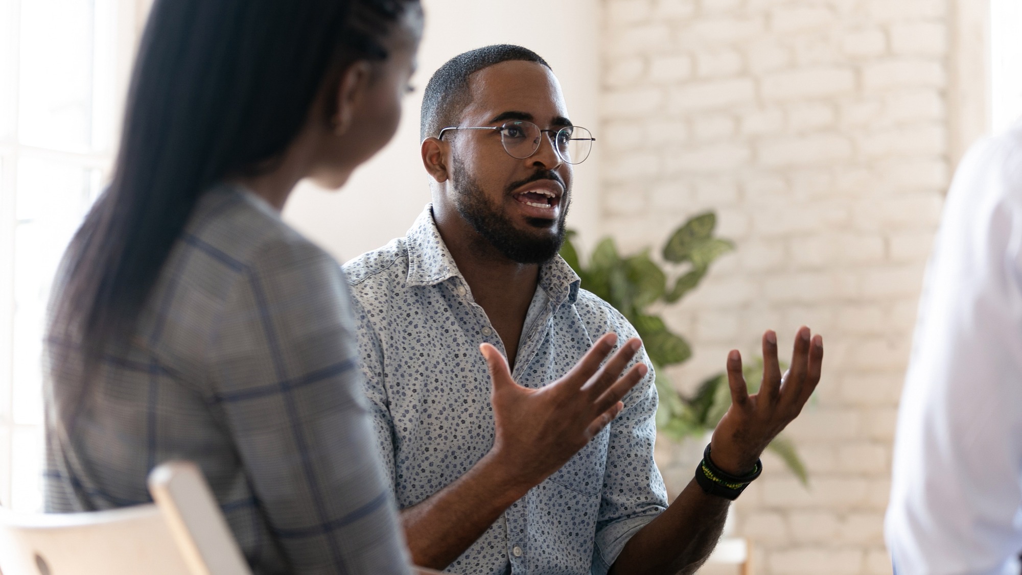 A man passionately discusses a topic with an attentive listener in a bright, modern setting, emphasizing engagement and conversation.
